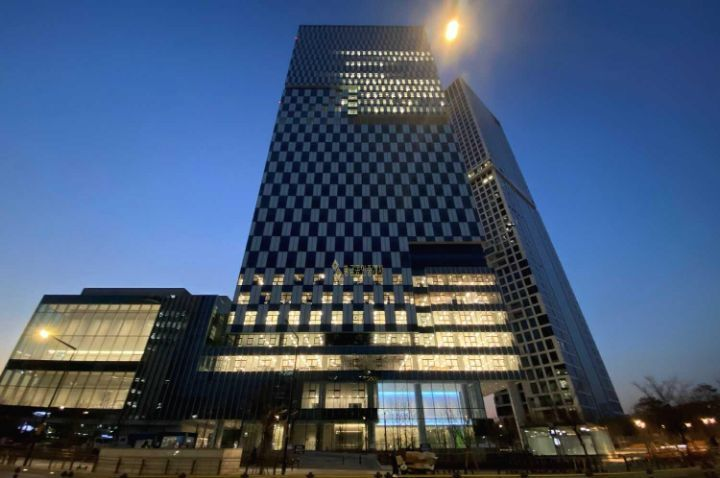 Das modern beleuchtete SM Entertainment Gebäude während der Abenddämmerung.