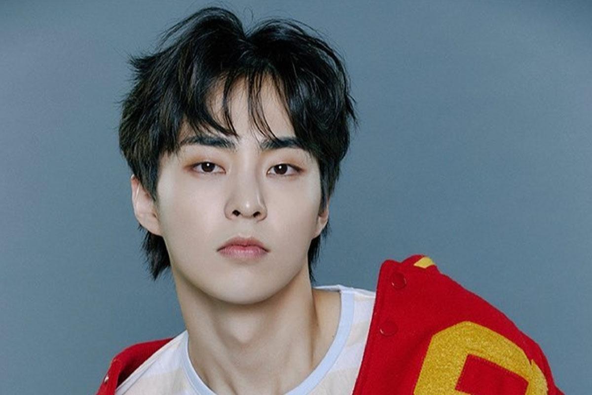 ชายหนุ่มใส่เสื้อแจ็คเก็ตสีแดง แจ็กเก็ตมีตัวอักษรสีเหลือง