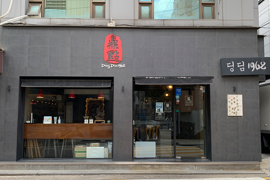 新沙站附近鼎點1968餐廳的外觀，黑色的建築牆面上有紅色的鼎點1968招牌。