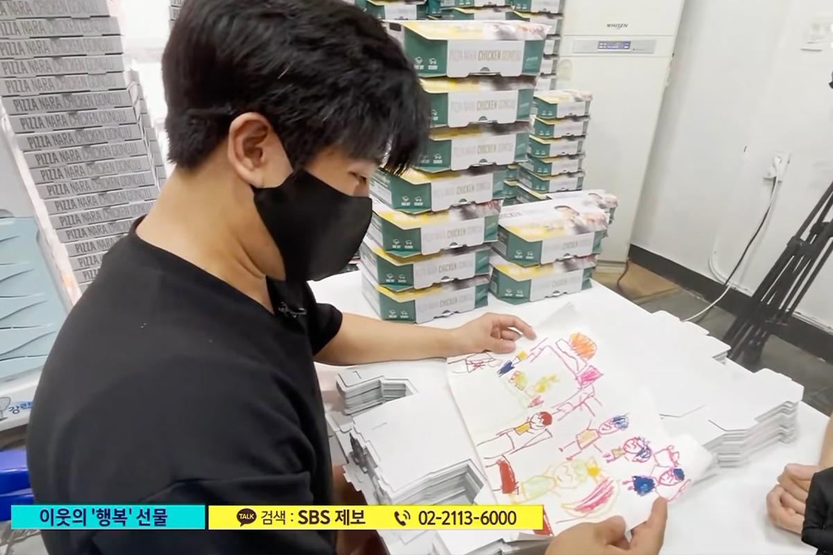 Pizza店老闆收到一幅孩子的畫，這是感謝他的回報，他表現出愉快和欣慰。