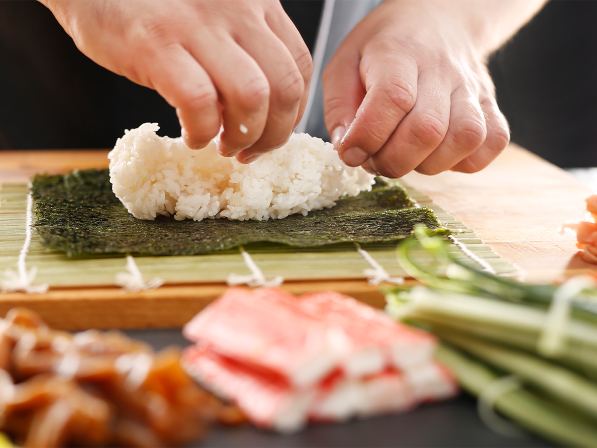 Préparation de gimbap par un travailleur sans changer de gants en plastique entre les commandes, une pratique hygiénique douteuse observée à Séoul