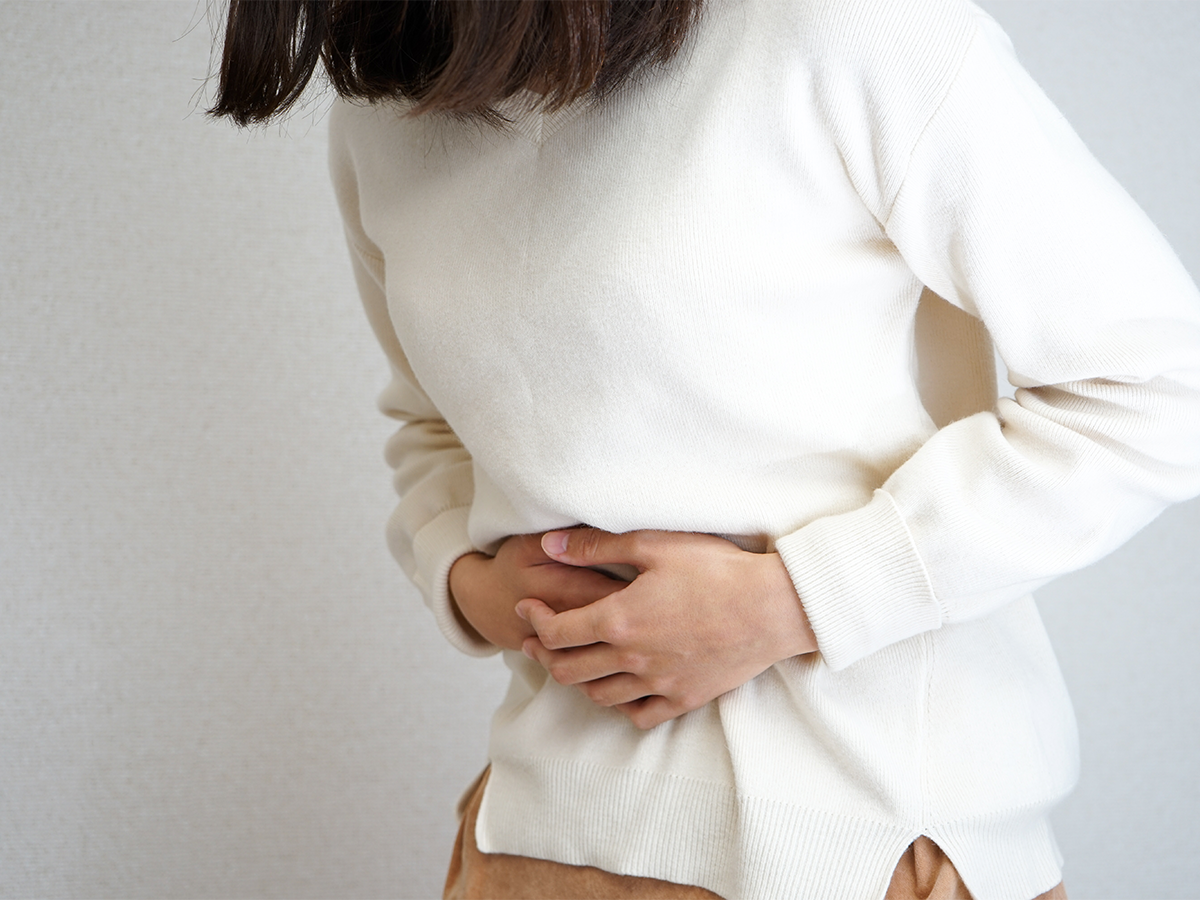 Personne souffrant de douleurs abdominales sévères après avoir consommé un aliment suspect, illustrant les symptômes de l'intoxication alimentaire