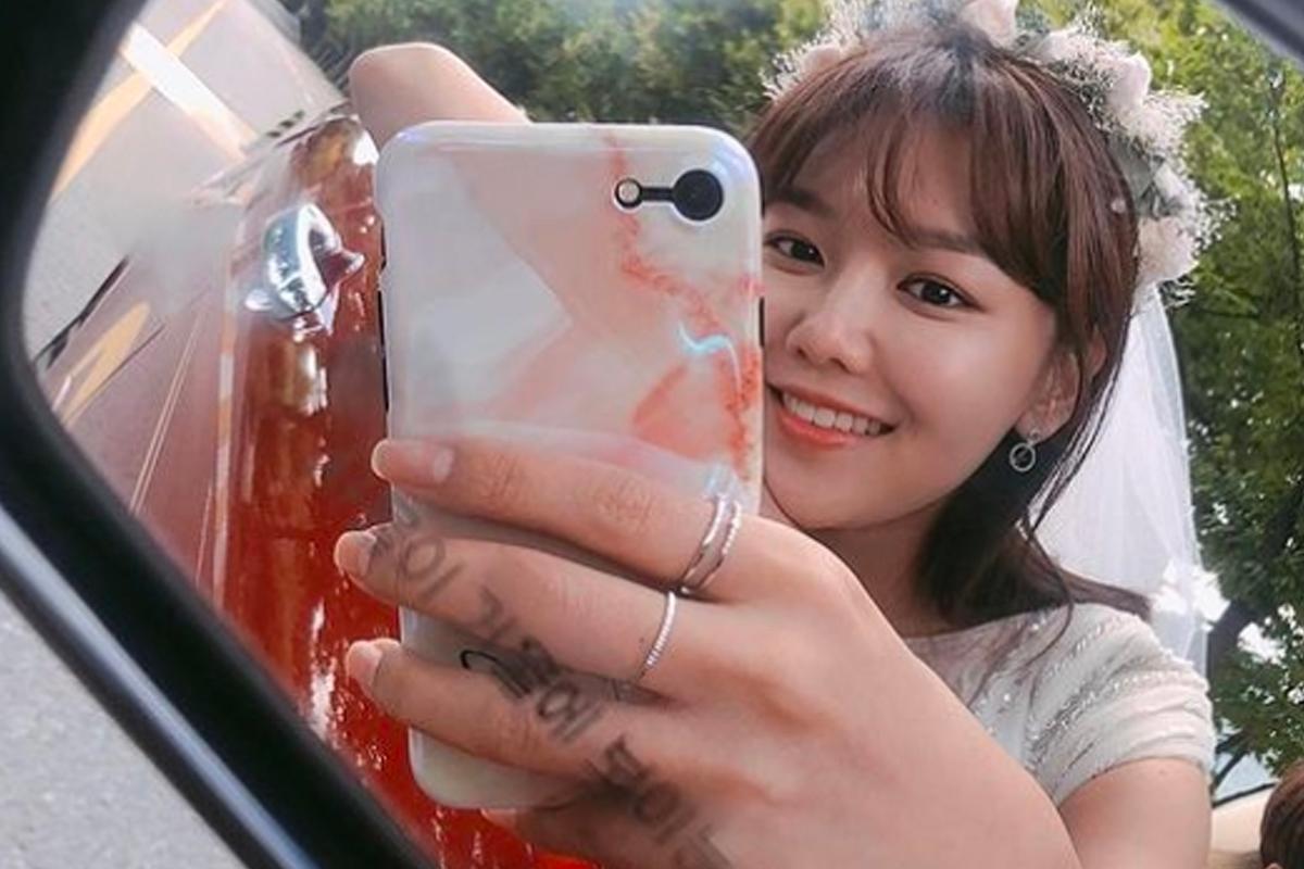 一位女子在車側倒後鏡中自拍，展現獨特的自拍角度和倒車鏡反射。