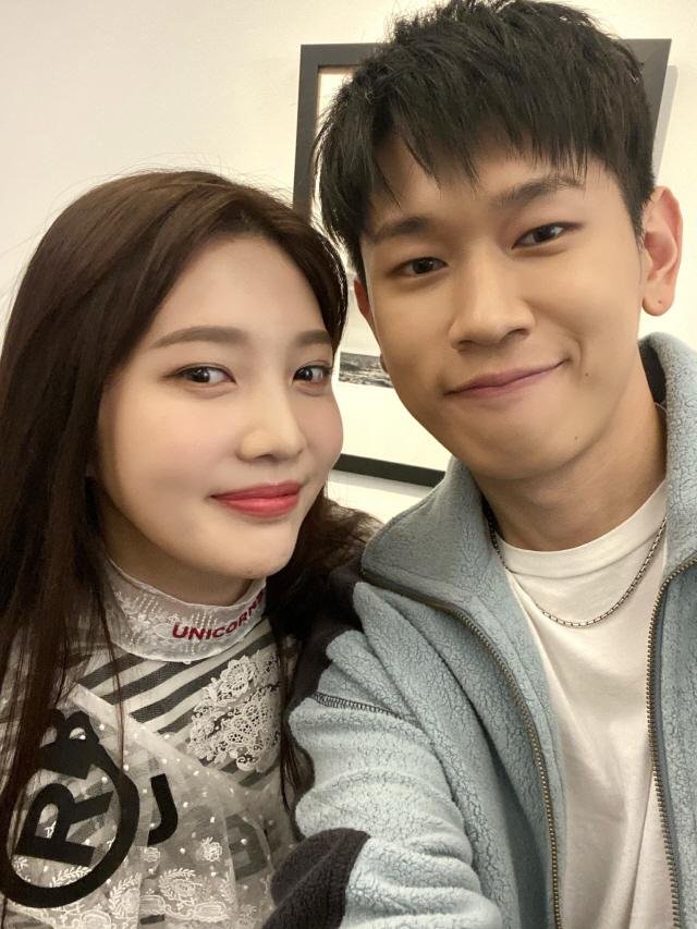 Chanteur Crush vêtu d'un blouson bleu pose aux côtés d'une amie, image floutée pour préserver leur anonymat.