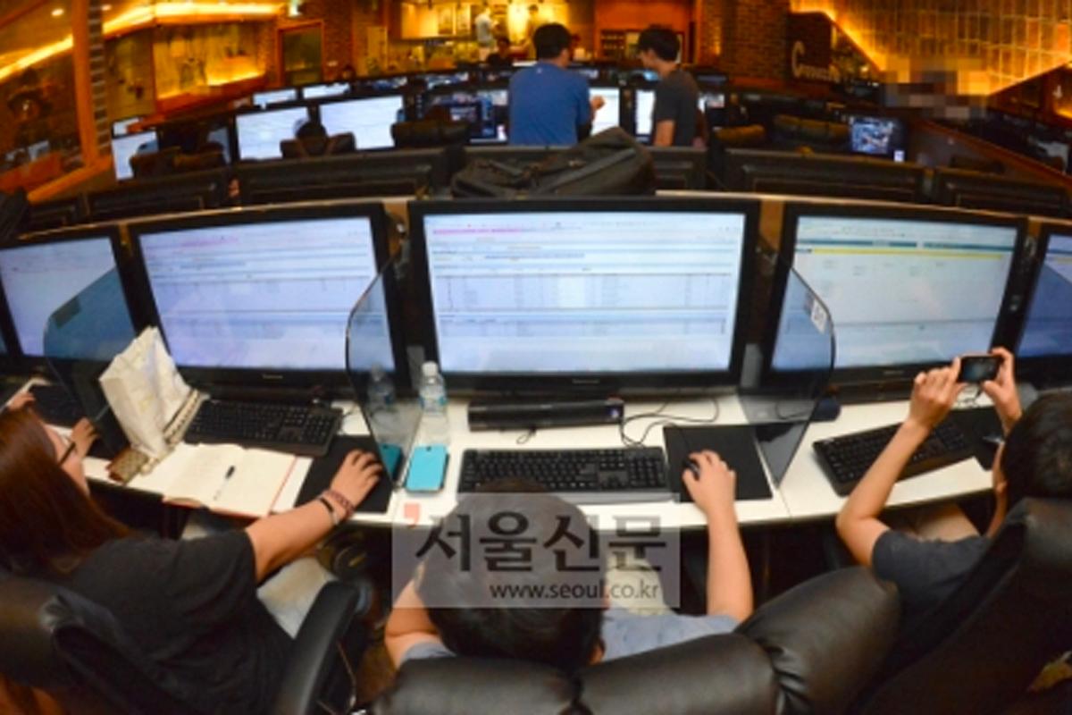 许多学生在网吧集中精神进行选课，一排排显示器和紧张的气氛显示出抢课的压力和竞争。