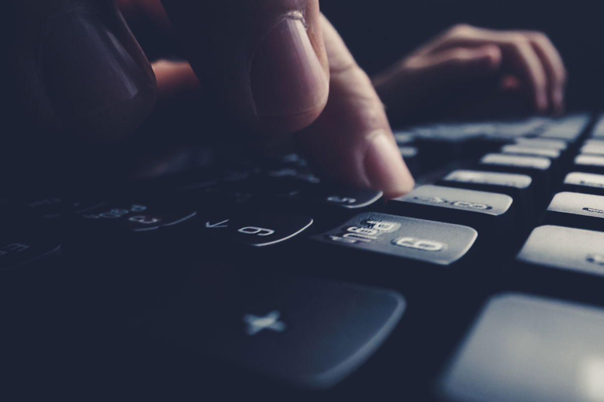 fingers touching a dark keyboard