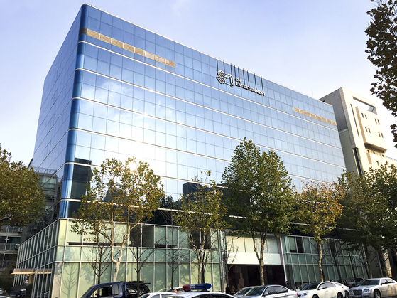 SM Entertainment компанийн оффисын барилга, гадаа талбайн мод болон зогсоолийн талбайтай хамт.