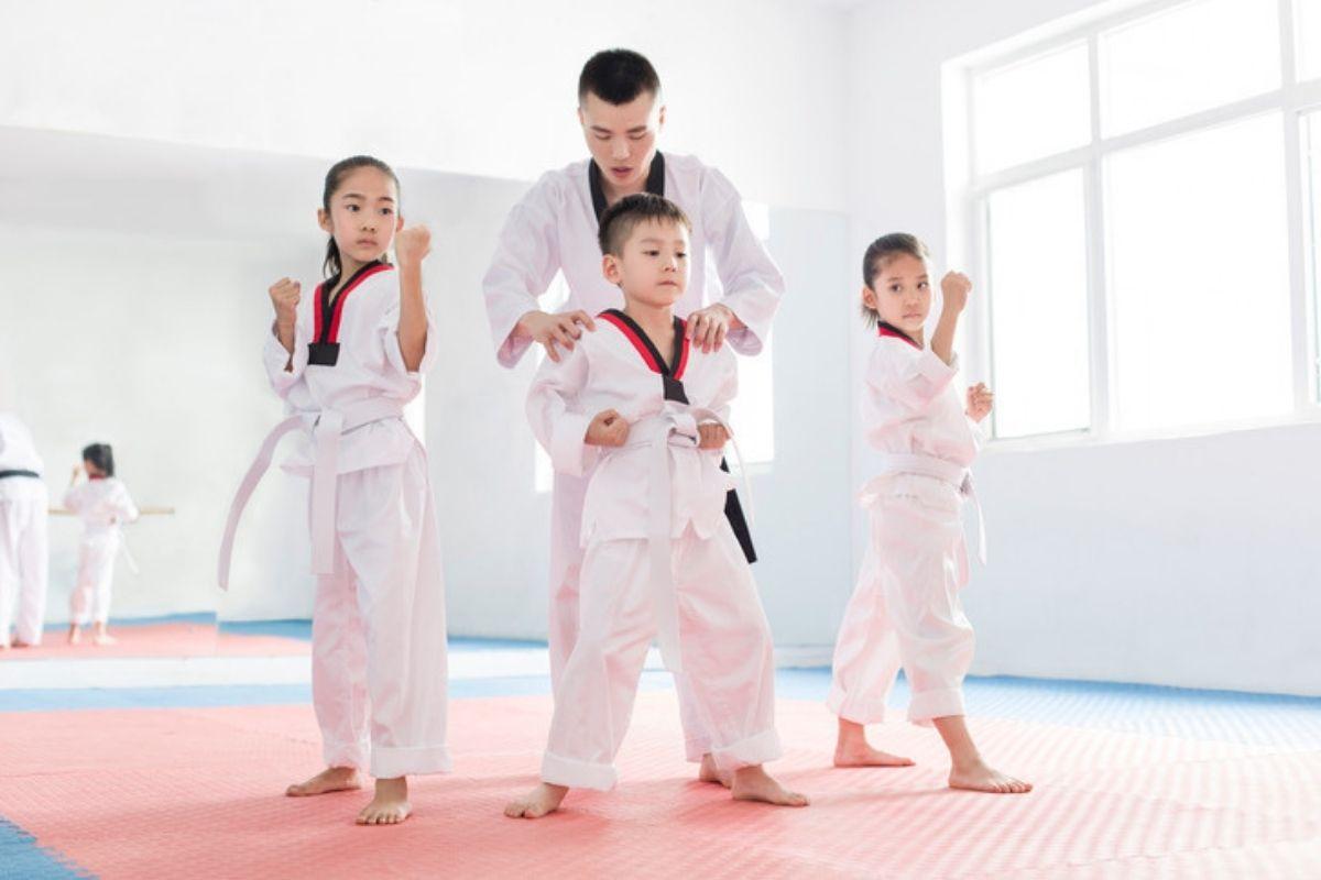 Thầy giáo Taekwondo hướng dẫn các em nhỏ, thể hiện vai trò giáo dục và xây dựng nhân cách qua võ thuật.