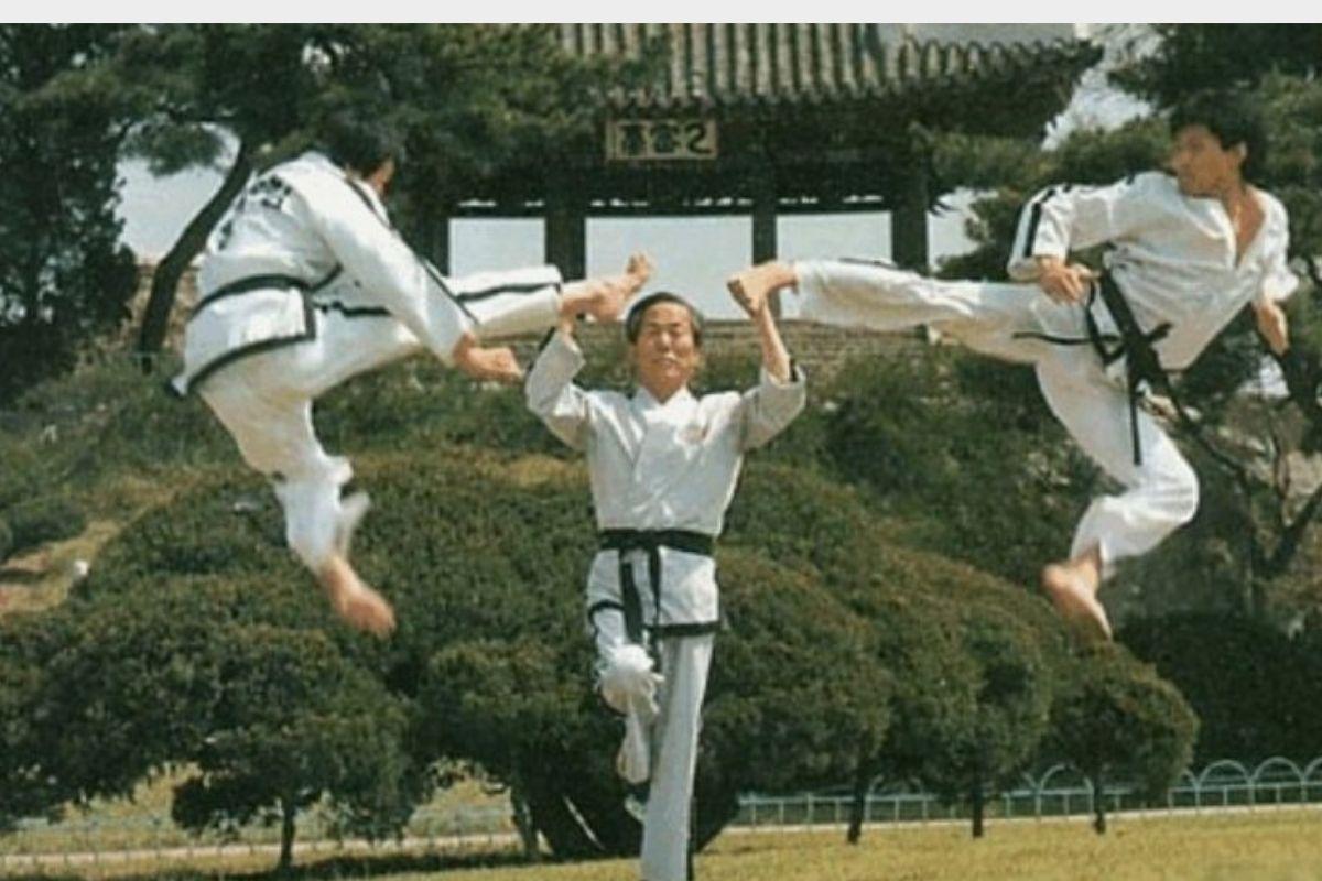 Ba võ sĩ Taekwondo đang thực hiện cú đá cao đồng loạt, biểu diễn kỹ thuật và sức mạnh môn võ.