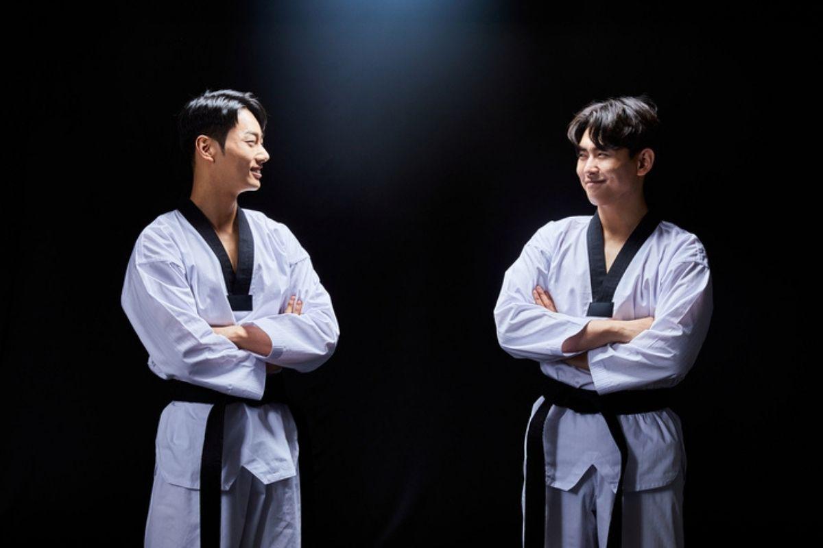 Hai võ sĩ Taekwondo trong bộ trang phục Dobok, biểu diễn kỹ thuật đòn tay và chân cơ bản.