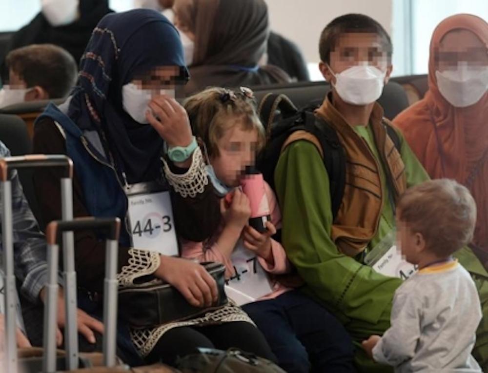 Afghan refugee family sitting in a waiting area at Incheon Airport, preparing to undergo COVID-19 testing.