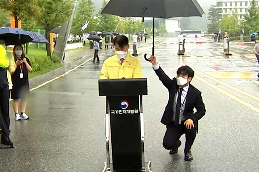 韩国忠清北道镇川公务员人才开发院外，法务部官员发表演讲，员工跪地为其撑伞的场景引发争议。