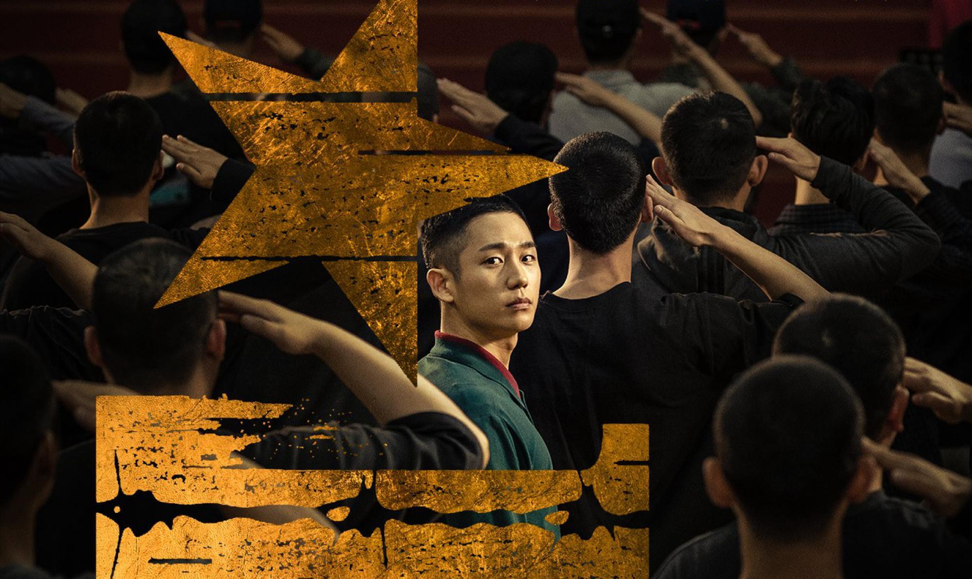 ทหารเกาหลีกำลังยืนทำความเคารพกลางแจ้ง ในภาพมีสัญลักษณ์ดาวสีทองขนาดใหญ่ที่เป็นสัญลักษณ์ของกองทัพ