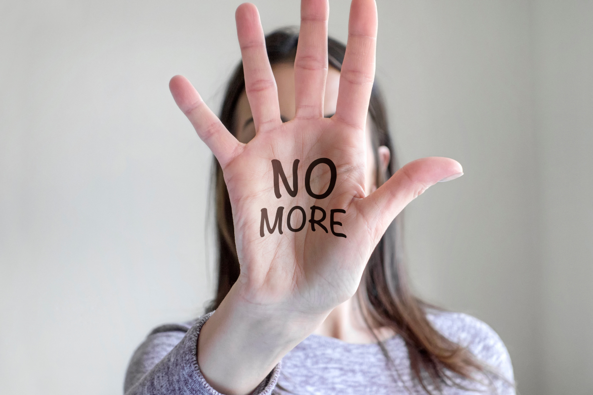 Hình ảnh bàn tay của người phụ nữ với dòng chữ 'NO MORE' biểu thị sự không chấp nhận bạo lực nữa.