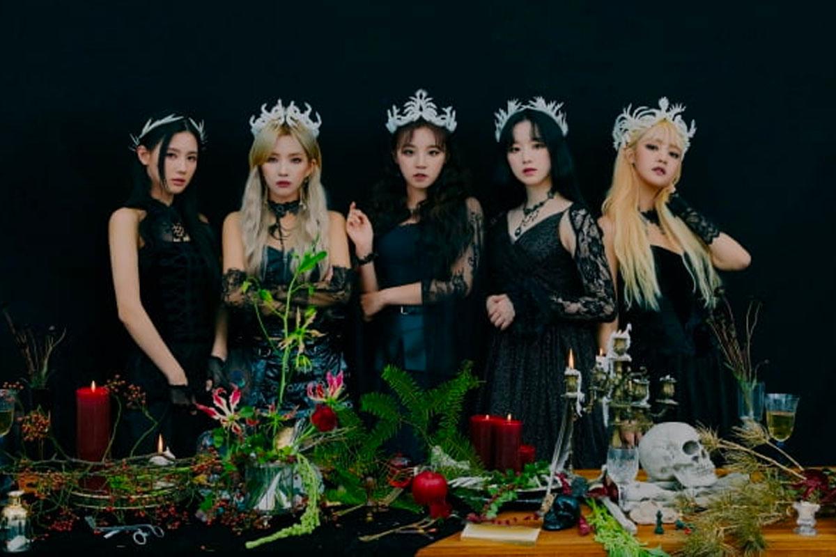 韓國女團 (G)I-DLE 成員穿著黑色閃亮禮服，搭配銀色飾品，在白色背景前，呈現出優雅成熟的形象。