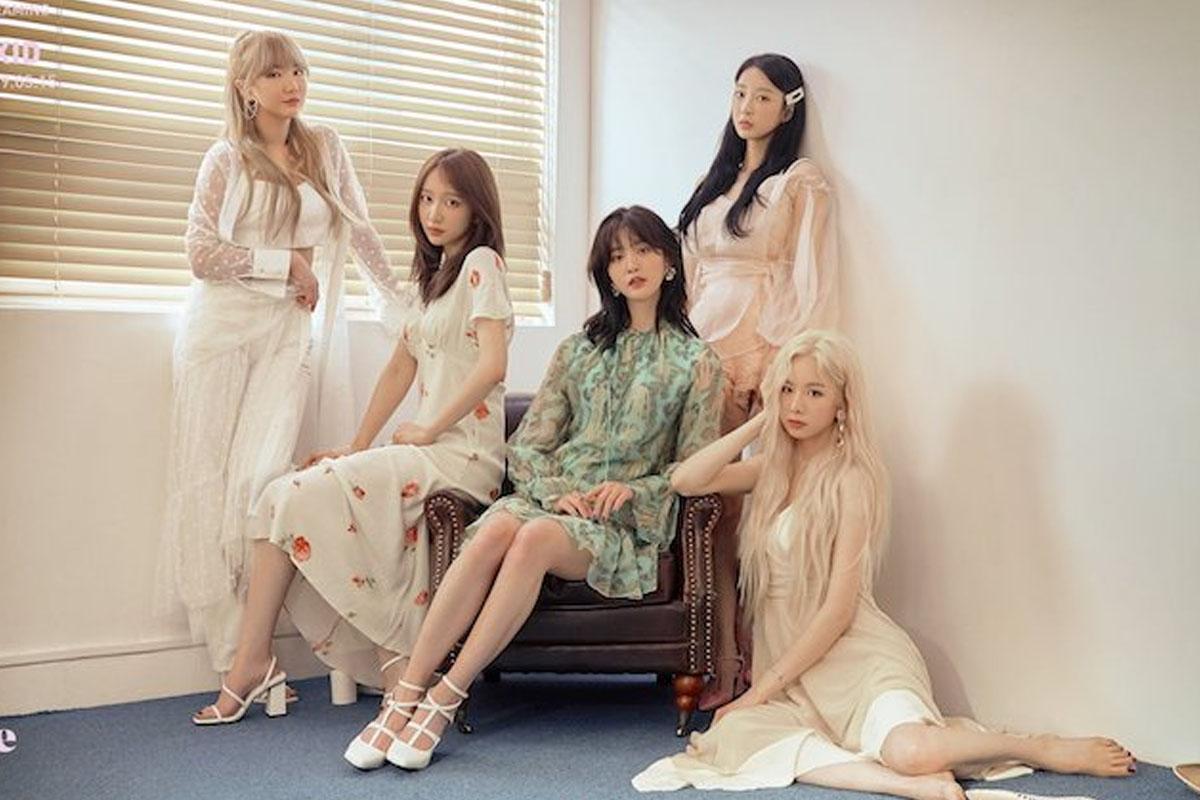 韓國女團 EXID 的成員們身著華麗的禮服，坐在沙發上，背景是一扇窗户，氛圍優雅而親密。