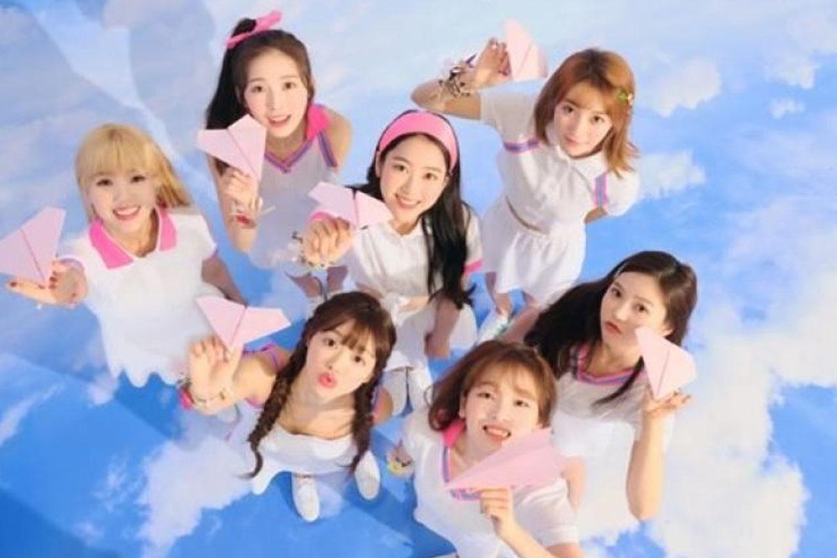 韓國女團 Oh My Girl 穿著白色服裝，站立於天藍色的背景前，展示出清新自然的形象。