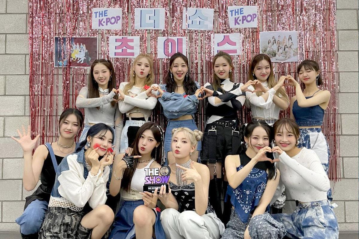 韓國女團 LOONA 穿著亮眼的服裝，站立於白色光亮背景前，展現出朝氣與活力。