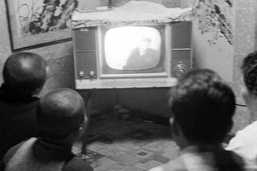 Black and white photo of people watching TV