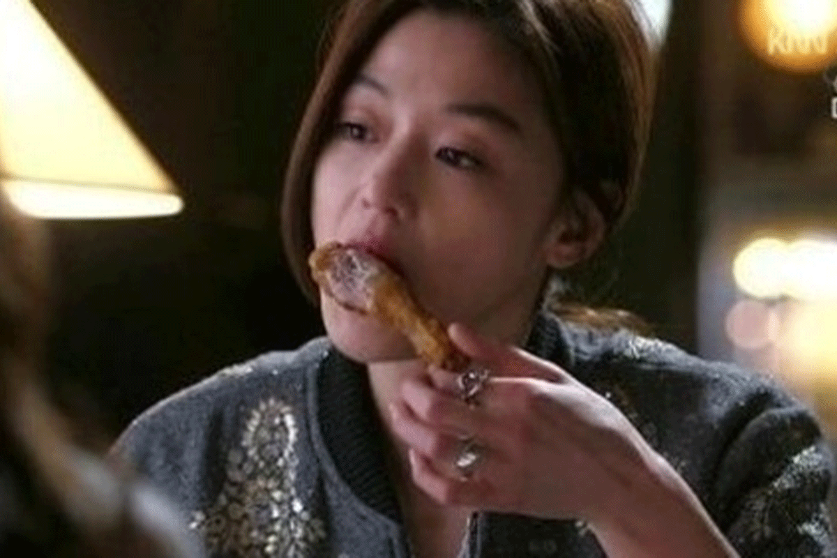 The History Of Korean Fried Chicken: woman eating a drumstick