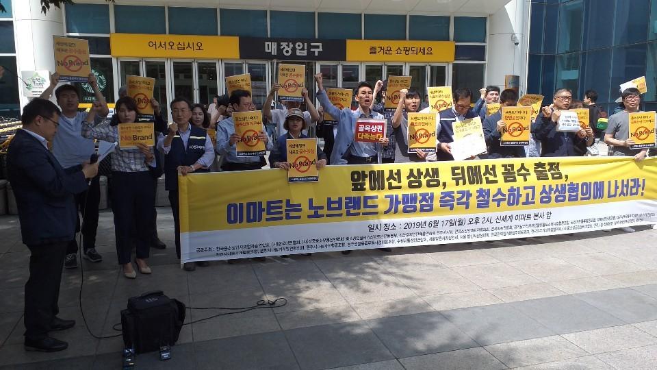 No Brand在傳統市場內被抗議的照片，人群舉起反對標語