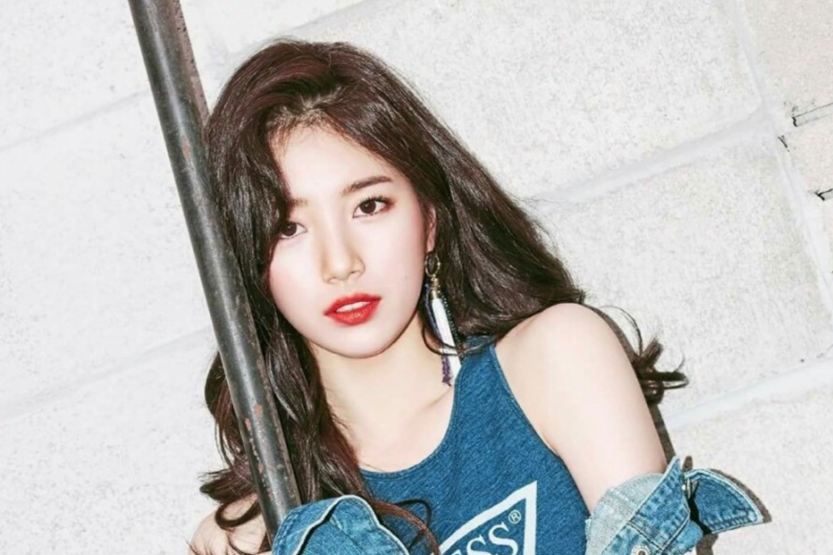 韓國女歌手站在白色牆前，身穿無袖牛仔服，面部模糊不清，配上隨性感服裝