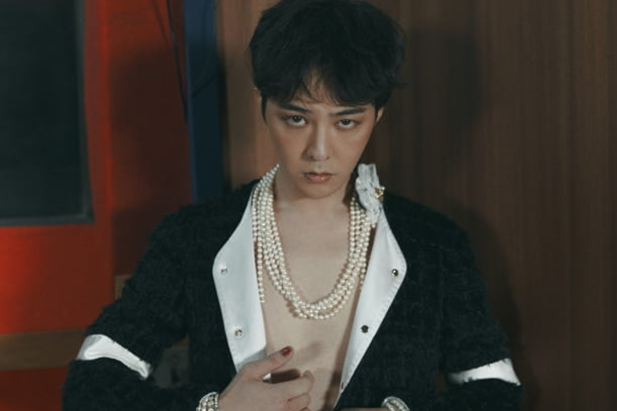 韓國男歌手身穿華麗珍珠配飾的時尚肖像，身體前景清晰，面部模糊，背景深色