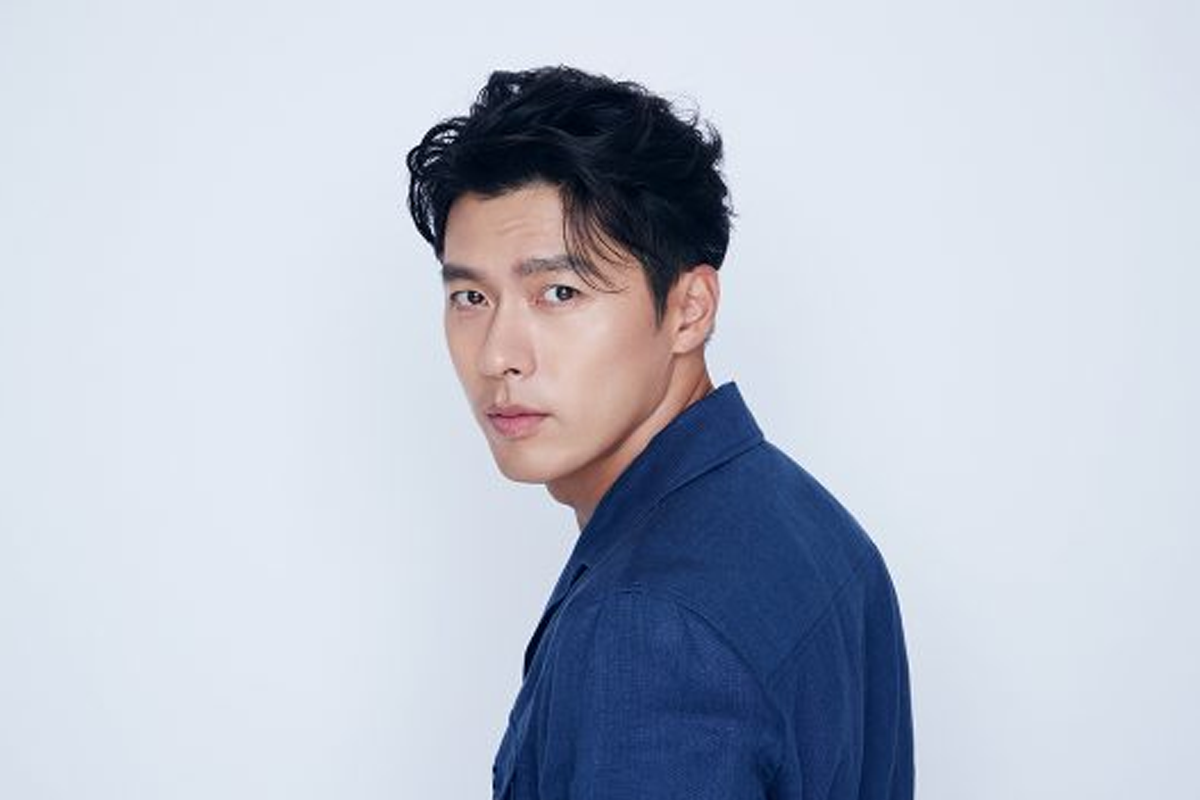 韓國男演員側面肖像，穿深藍色襯衫，面部模糊，背景淺藍色，展現簡約風格