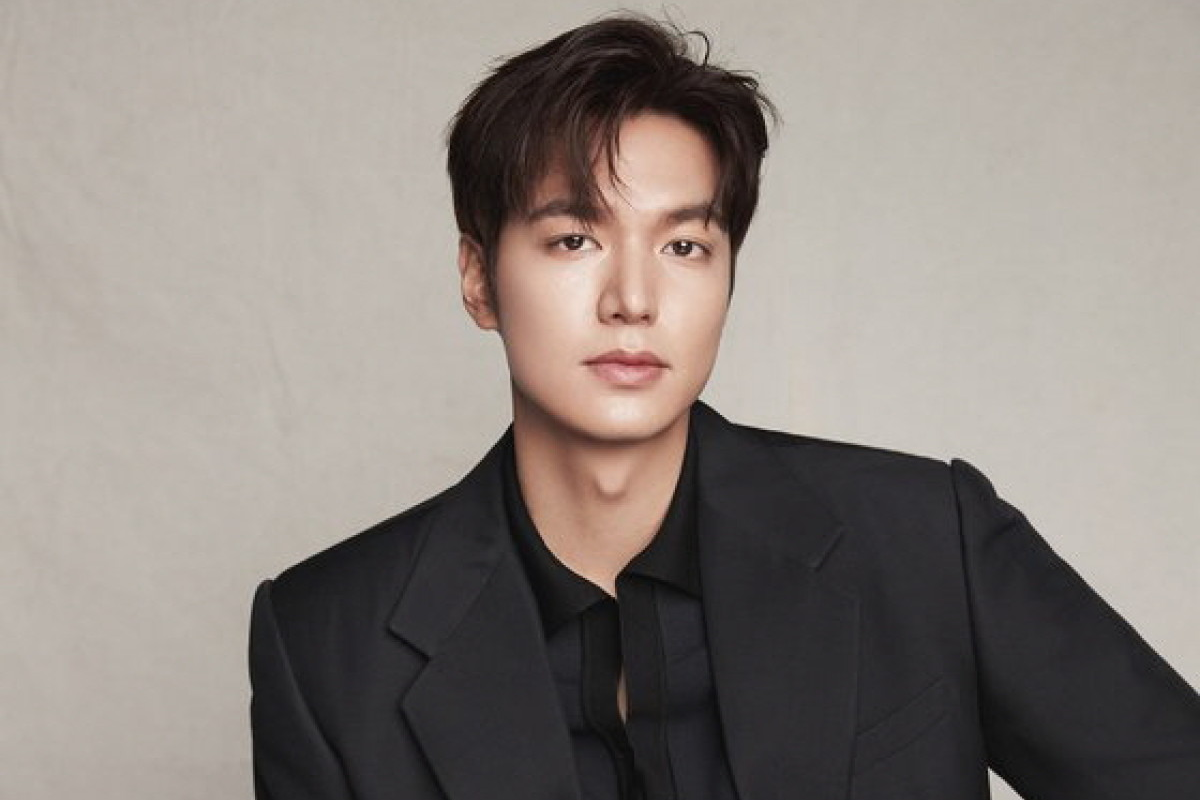 韓國人氣男演員身穿黑色正式西裝，面部模糊，背景為淺色簡約風格，呈現專業形象