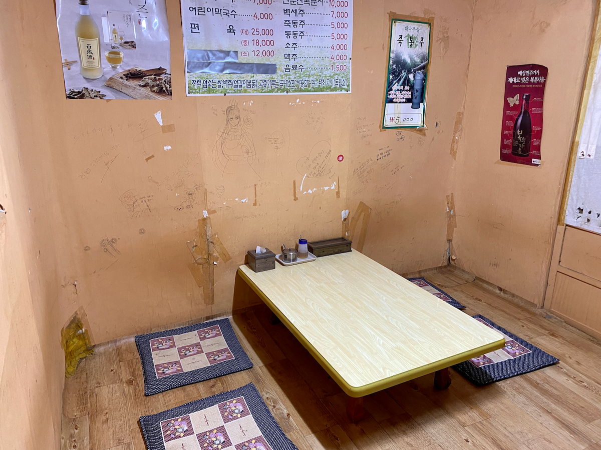 Dining area with wooden table and sitting cushions at Maok Nongaundaejip