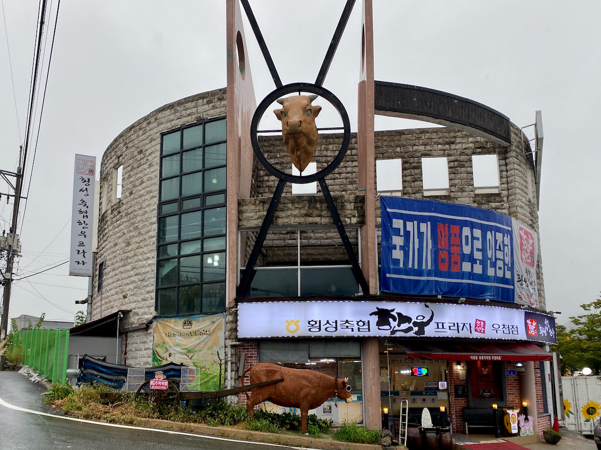 Hoengseong Hanwoo Village restaurant exterior with a giant cow head