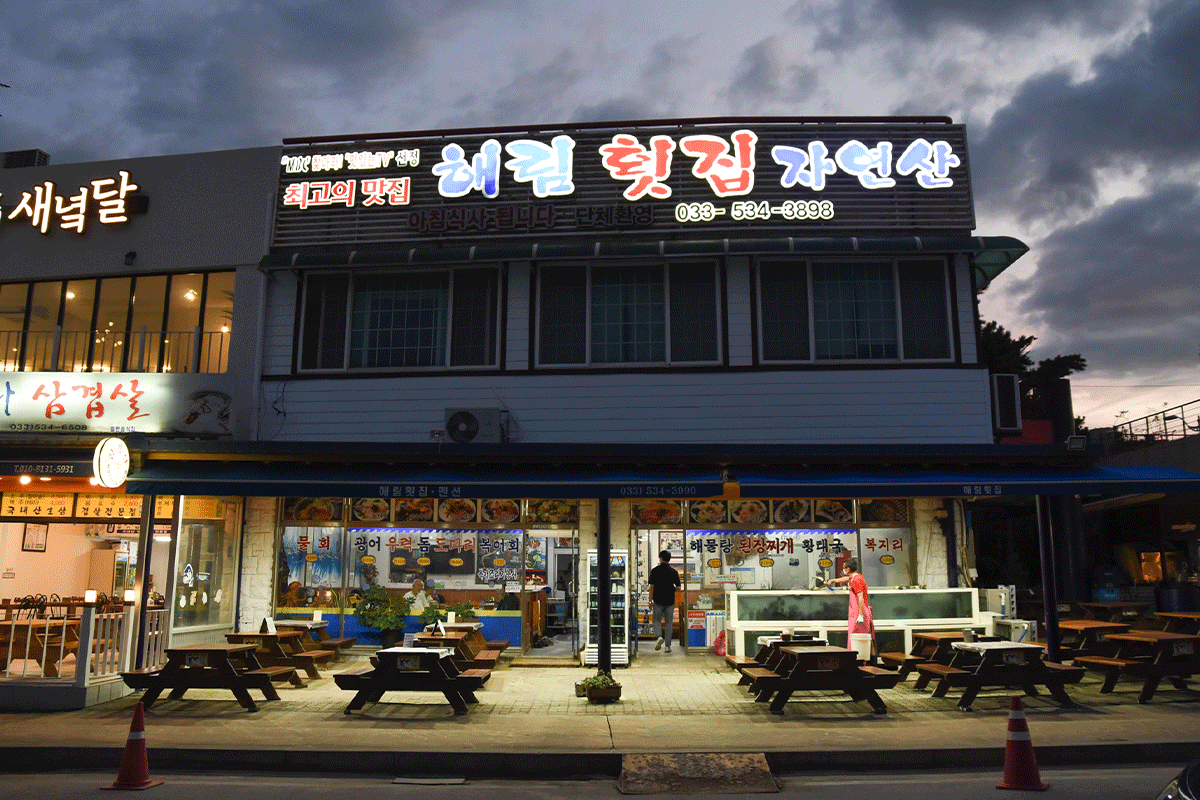 Nhà hàng Haerim tại Donghae, nổi bật với bảng hiệu sáng và sân ăn ngoài trời, nơi cung cấp món Mulhoe truyền thống Hàn Quốc.