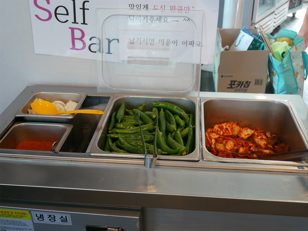 Pyeongi Dambaek Ppyeokalguksu side dish and condiment counter