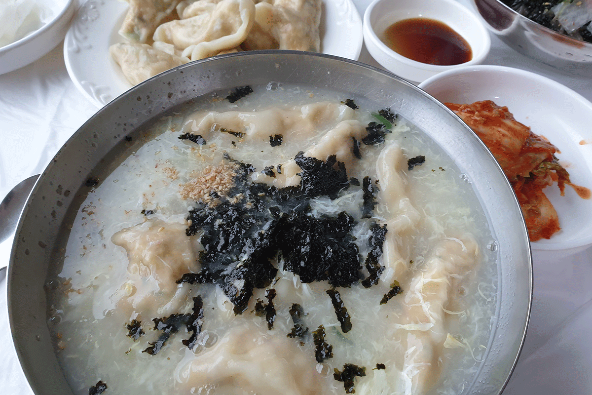 Bát súp bánh bao gà lôi (Súp Mandu) hấp dẫn, chứa nhiều bánh bao, rong biển, trứng, và hành lá từ quán Namgyeong.