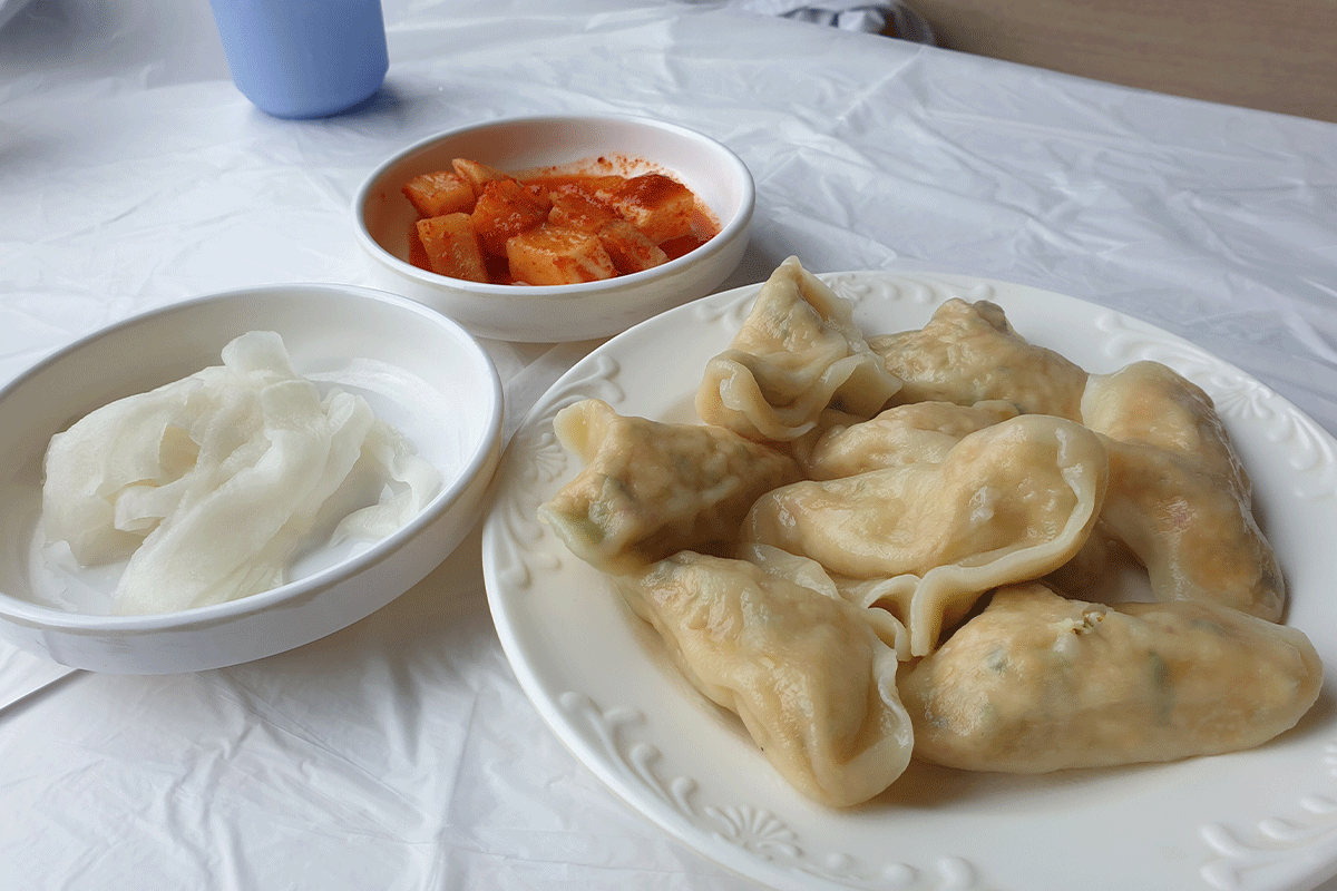 Đĩa bánh bao Mandu ăn kèm với kim chi và củ cải ngâm, món khai vị phổ biến tại nhà hàng Pyeongchang Namgyeong.