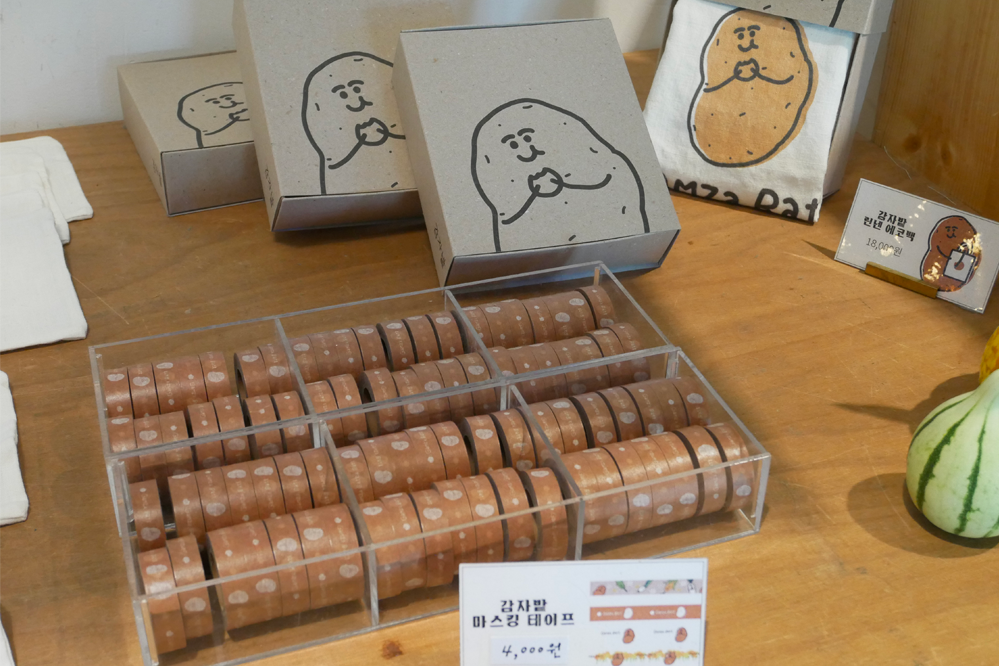 展示馬鈴薯田咖啡廳內出售的特色商品，周邊產品，如紙膠帶和托特包。