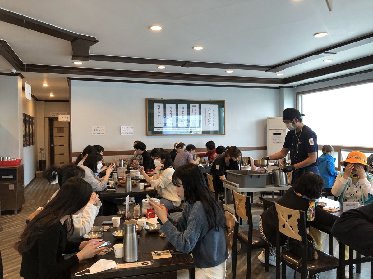 one day tour itinerary, cheorwon gangwondo korea, people sitting at tables in pyeongi dambaek ppyeokalguksu