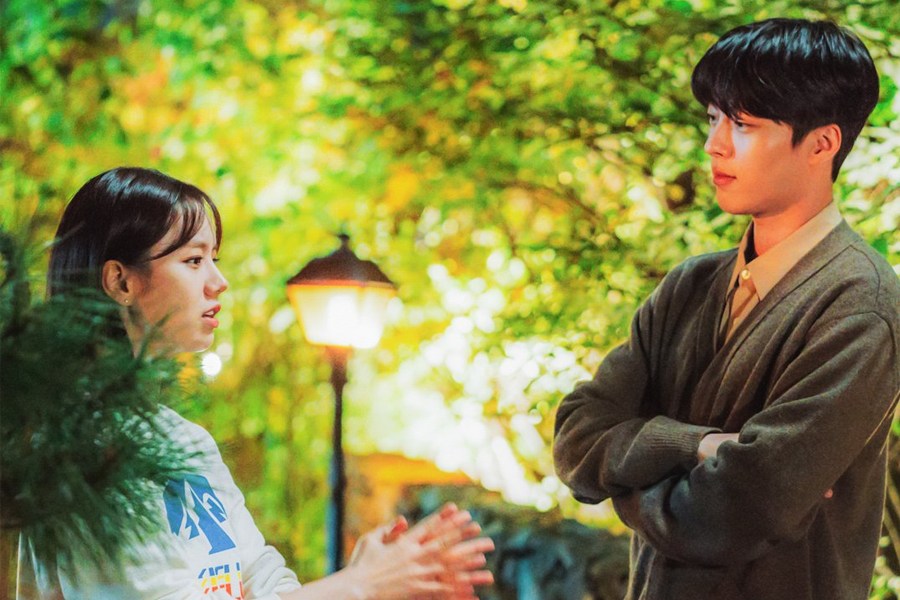 韩国情侣在室外花园的谈话画面，背景浪漫，象征着爱情的萌芽。