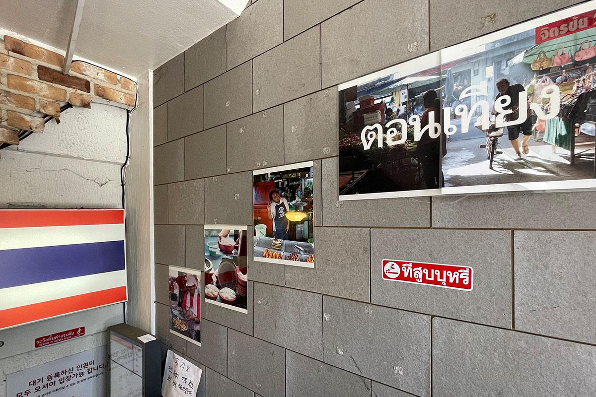 cờ Thái được dán ở hành lang lối vào Krap Pom: Nhà hàng Thái yêu thích ở Hàn của Blackpink Lisa, CLC Sorn và G(I)DLE Minnie