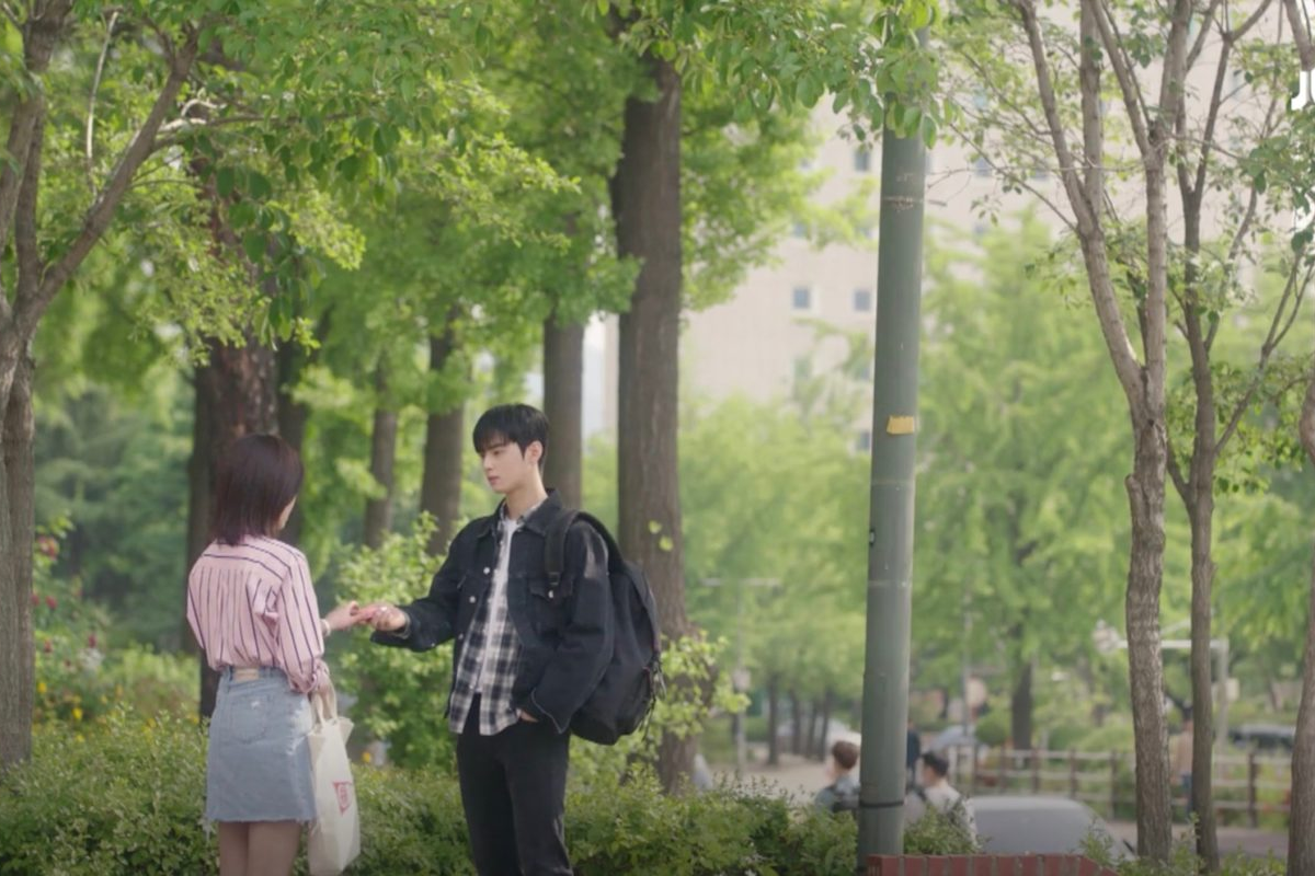 Due persone si incontrano lungo un sentiero alberato nel campus dell'Università Konkuk