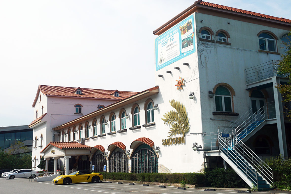 聖托里尼餐廳外觀,展示其典雅的白色結構,位於春川九峰山咖啡街,有住家式風格