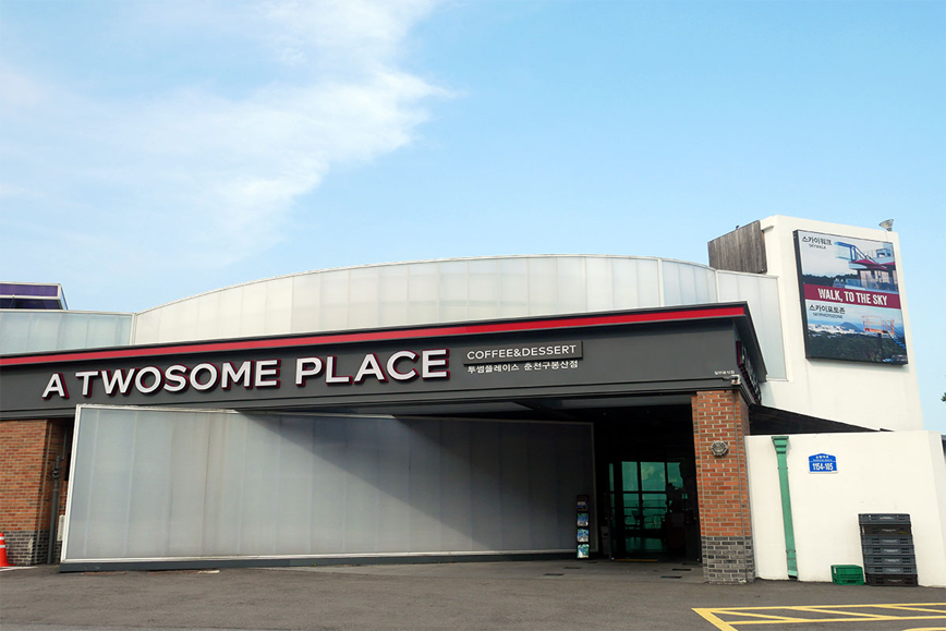 A TWOSOME PLACE咖啡廳的一層正面圖,展示著店門入口和販售咖啡甜點的招牌