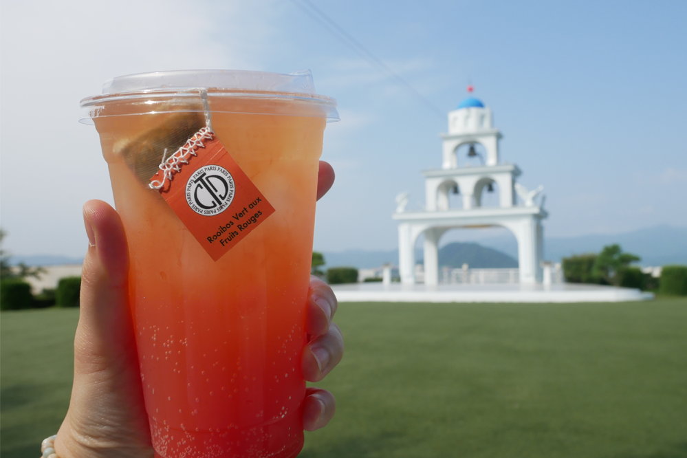 葡萄柚飲品與聖托里尼餐廳鐘塔作為背景,飲品展示使其成為焦點