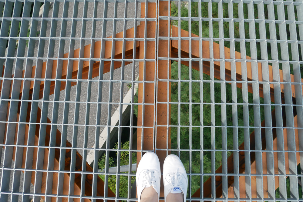 九峰山SkyWalk展望臺的透明地板視角,展示旅客鞋子的特寫畫面,增添獨特體驗