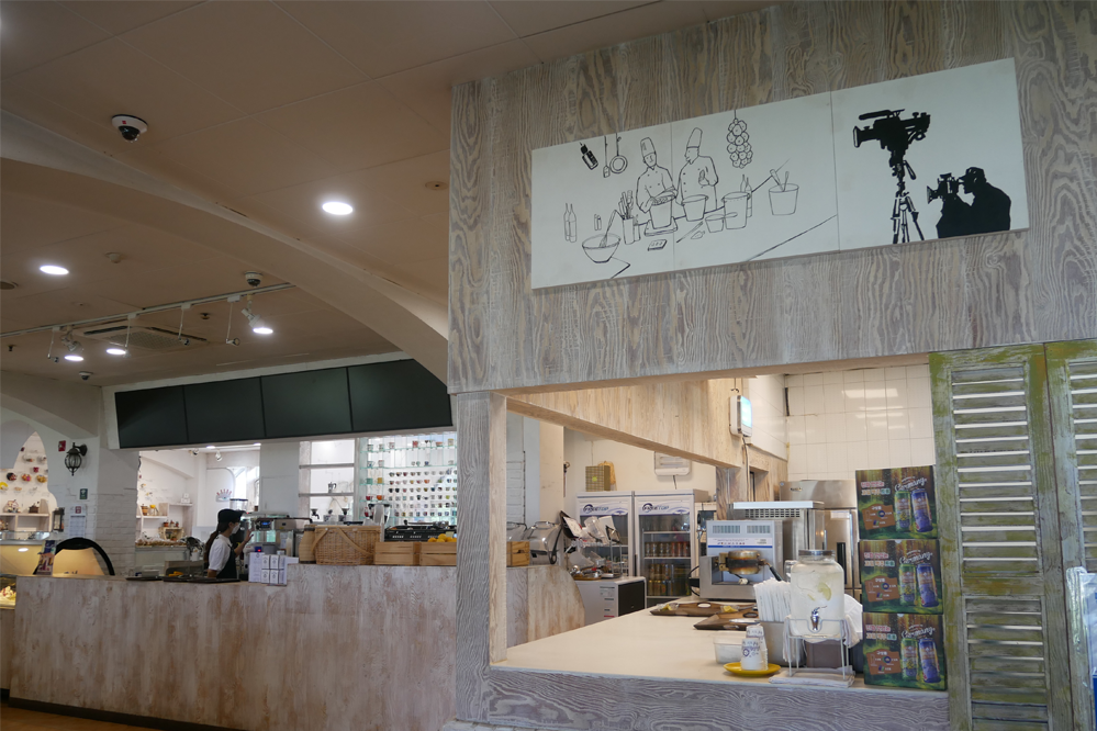 聖托里尼咖啡館的櫃檯展示,牆上掛有插畫,營造出藝術氛圍