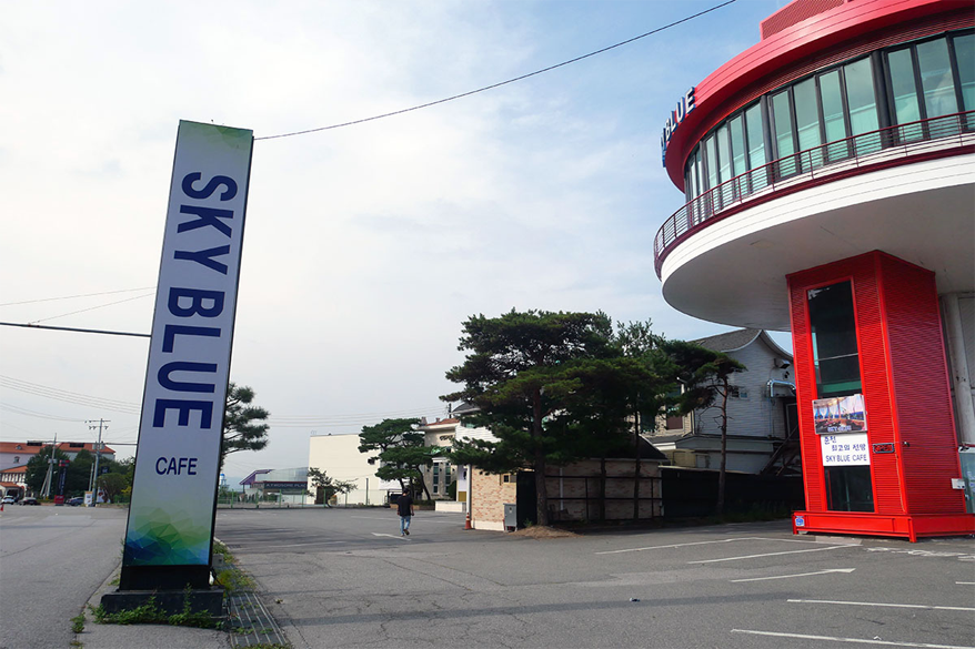 九峰山SKY BLUE咖啡廳外觀,背景是藍天和幾棵樹,咖啡廳建築呈現出現代感,適合觀賞風景的好去處