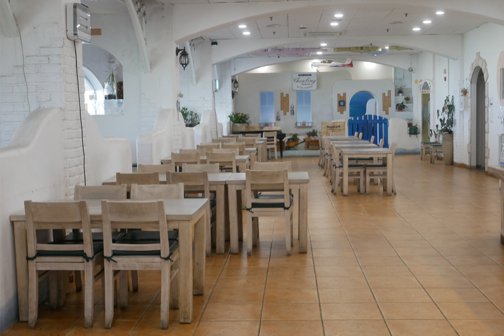 聖托里尼餐廳室內的用餐區域,擺放著整齊的木製桌椅,是享受美食的愜意地方