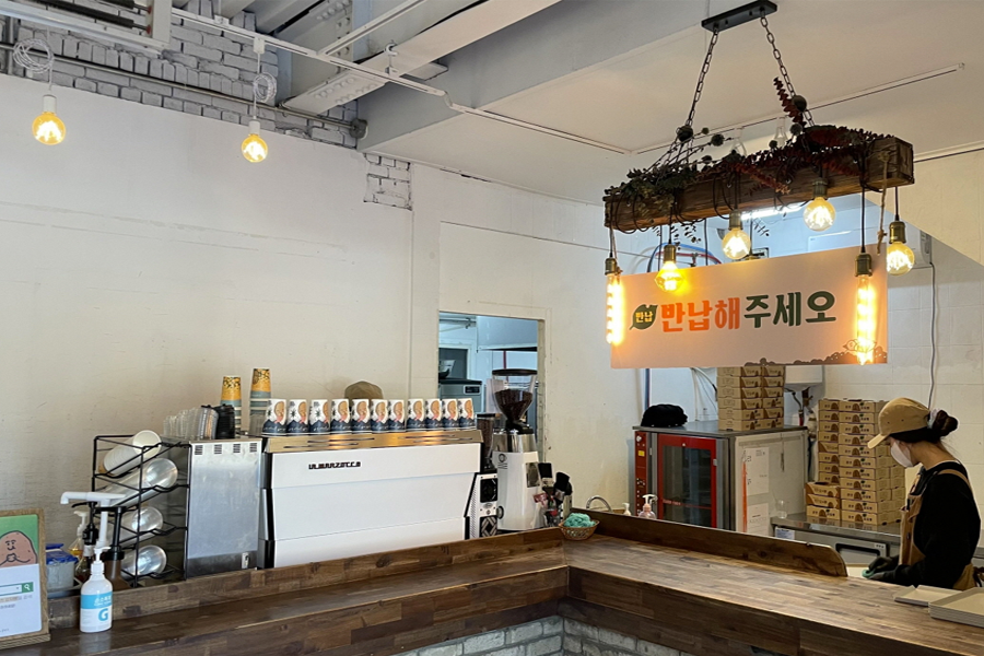 春川马铃薯田咖啡厅内的忙碌景象，装饰灯笼挂在天花板上，营造舒适的用餐环境。