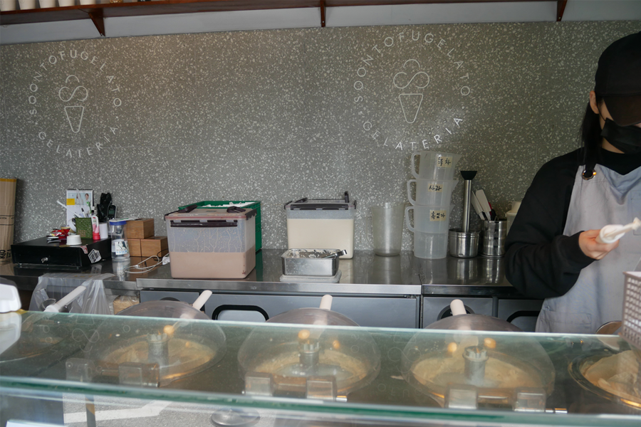 在 'SOONTOFUGELATO' 店內，顯示冰淇淋容器和工作人員。