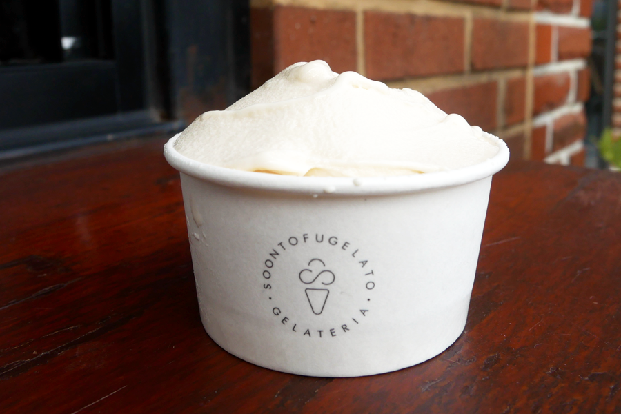 豆腐冰淇淋近拍，顯示光滑綿密的質地，紙杯上寫有 'SOONTOFUGELATO' 的標誌。
